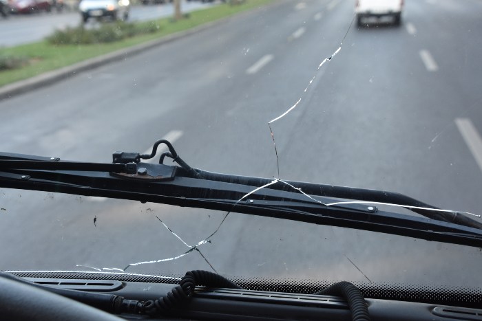 Broken windshield glass and wires strewn across the road, highlighting damage in Langley, B